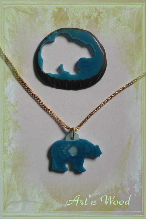 création sur-mesure, un bijou unique représentant une silhouette d`ours en corozo avec patte gravée sur le fond bleu - Art`n Wood, créatrice de bijoux artisanaux en matières précieuses naturelles